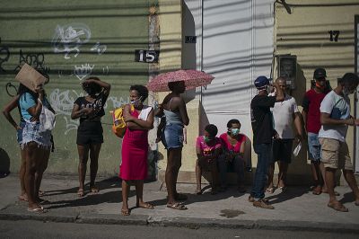 People stay outside the government-run Caixa Economica bank to receive economic aid amid the new coronavirus pandemic in Rio de Janeiro, Brazil, on April 29, 2020. - Brazil, the South American country worst-hit by the coronavirus pandemic, has registered more than 5,000 deaths from COVID-19, the health ministry announced Tuesday, pushing the toll above that of China. (Photo by Mauro Pimentel / AFP)